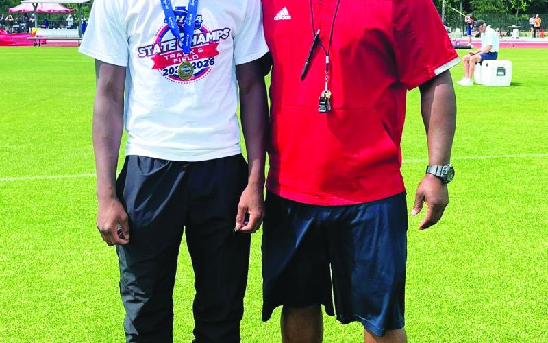 Bill Waters (left) and Putnam County track and field coach Kedric Manning (right) pose after Waters won the state championship. CONTRIBUTED