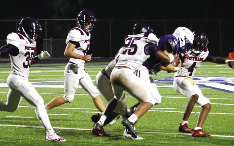 A pack of War Eagle defenders tackle Oconee County’s Jake Johnson during a scrimmage last season. LANCE McCURLEY/File Photo
