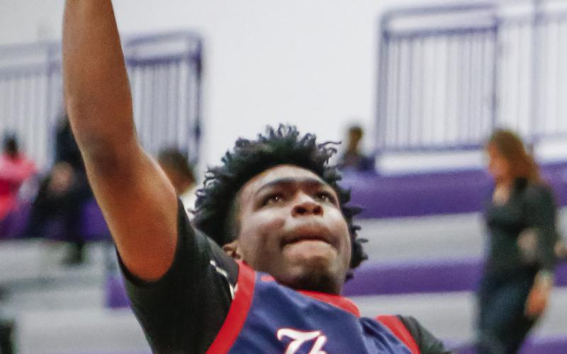 Jmari Greene leaps over Commerce defenders as he attempts a layup. LANCE McCURLEY/Staff