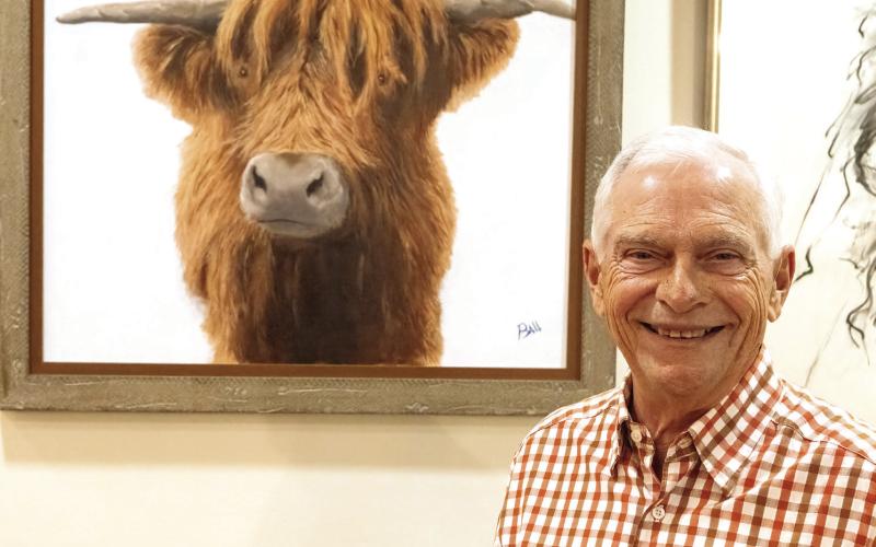 Artist Chris Ball in front of one of his paintings at Festival Hall. LEIGH LOFGREN/Staff