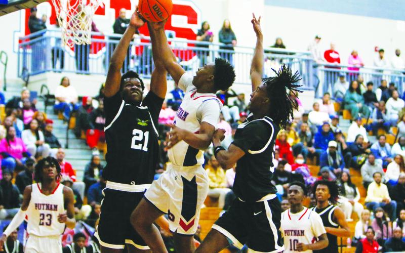 Putnam County’s Jmari Greene goes up for a layup but is met by two Greenforest defenders who attempt to block his shot. LANCE McCURLEY/Staff