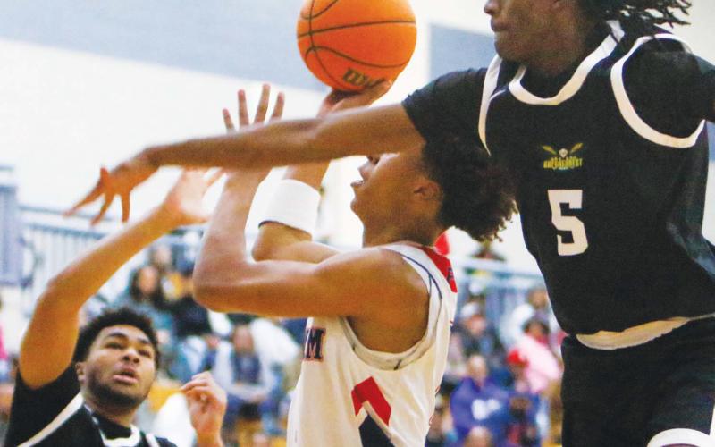 Putnam sophomore Jeremy Banks attempts a layup between Greenforest’s Dallas Stephens (2) and Bryce Irby (5). LANCE McCURLEY/Staff