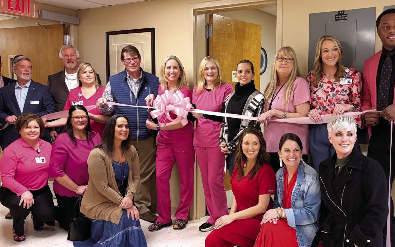 Putnam General Hospital staff and local officials, including Putnam County Clerk of Courts Trevor Addison (far left) and Eatonton-Putnam Chamber of Commerce CEO Robbie King, with Putnam General CEO Alan Horton (second and third from left, respectively), join office and medical staff members in celebrating the installation of a high-tech mammography machine at the Eatonton-based medical center. SKYLA MORRIS/Staff