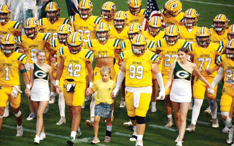 As part of their annual "Goldout" event, the Gators in special uniforms were accompanied by cheerleaders and Gatewood grade schooler "Cami" (center), who also sang the national anthem prior to the game's start. (IAN TOCHER/Staff)