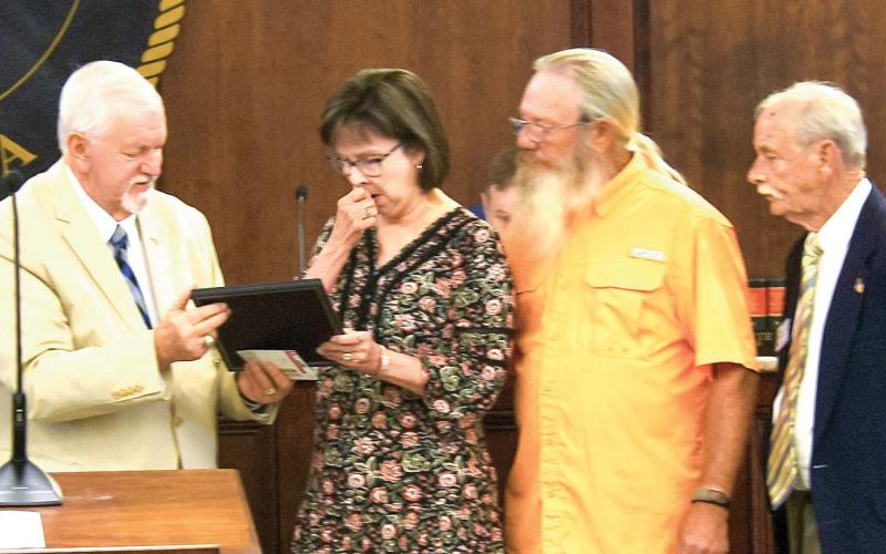 Retiring Senior Personal Property Appraiser Leisa Reid reacts to receiving an official Putnam County proclamation recognizing her 48 years of service to the county from Chairman Bill Sharp prior to last Friday’s county commission meeting. IAN TOCHER/Staff