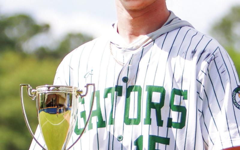 Lawson Wooten holds the 2024 GIAA-2A championship trophy after closing with two scoreless innings for the Gators in Macon. (LANCE MCCURLEY/Staff)