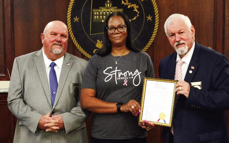 Before the start of the Oct. 4 Putnam County Commission meeting, Commission Chairman Bill Sharp (holding frame) invited County Human Resources Director Cynthia Miller to join him and (l-r) Commissioners Daniel Brown, Jeff Wooten, and Stephen Hersey in a proclamation recognizing the month of October as Breast Cancer Awareness Month. IAN TOCHER/Staff