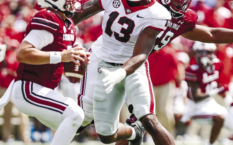 Georgia defensive lineman Mykel Williams (13) closes in on South Carolina quarterback Spencer Rattler ( ADAM WALSH/UGA Athletics 7) during Saturday’s game.
