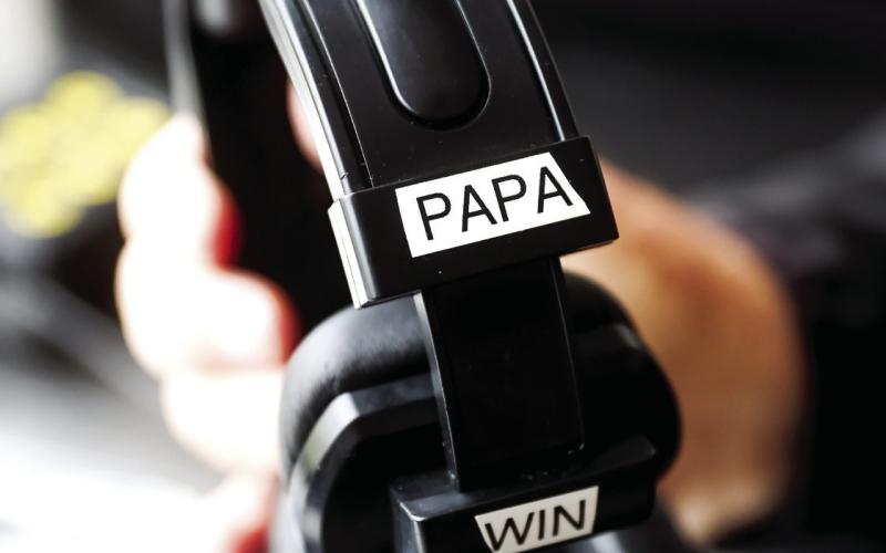 Winslette holds his headset labeled 'Papa Win' in the visiting coaches box at Morgan County High School. Abbey Cutrer/AJC