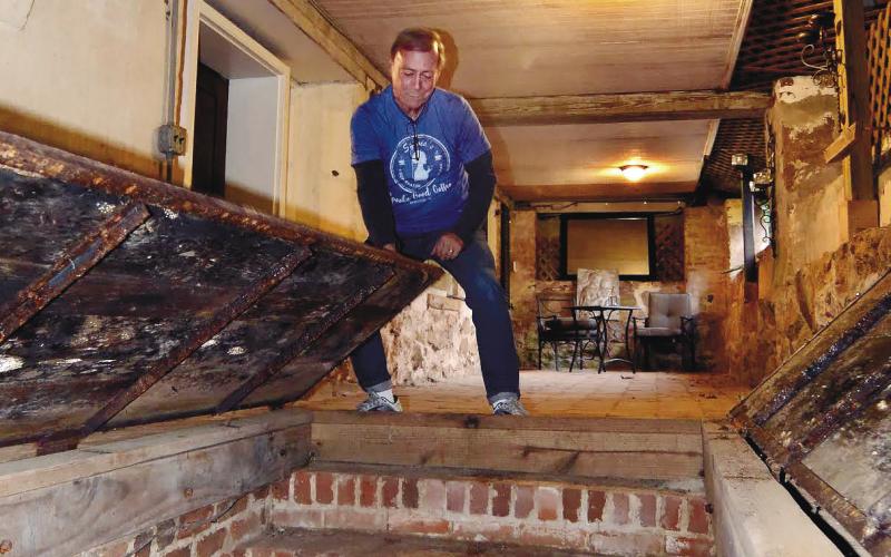 Homeowner Michael Homeier opens a large trapdoor to expose a steep staircase leading to a hidden room and the entrance to the tunnel beneath Panola Hall.
