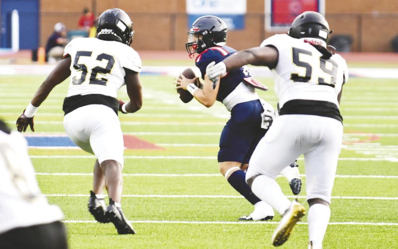 Putnam quarterback Branan Griffin tries to get the ball away quickly as Greene County defensive linemen Dayshaun Copeland (52) and Jamarion Evans (59) are in hot pursuit. BRENDAN KOERNER/Staff