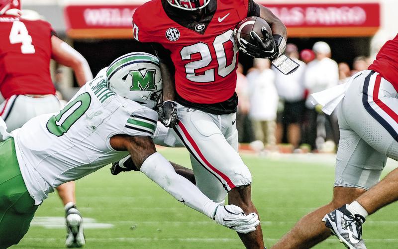 Georgia sophomore running back Dwight Phillips Jr. (20) brushes off a Marshall defender on his way to the end zone. UGA ATHLETICS
