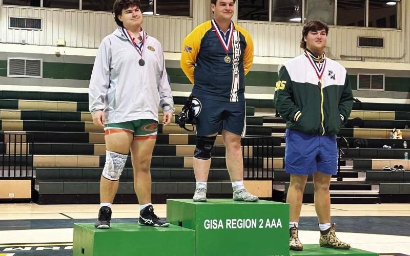 Gatewood senior Tyler Middleton (center) won the region championship at 285 pounds. CONTRIBUTED