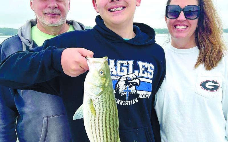 Tom, Evan and Monica Wehman with Evan’s first striper from Lake Sinclair. CONTRIBUTED