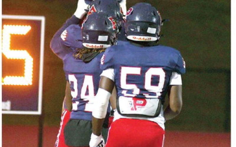 War Eagles quarterback Ethan Whatley is hoisted high above the end zone by teammates Friday night after scoring his first of five touchdowns just 44 seconds into the game against Utopian Academy. IAN TOCHER/Staff