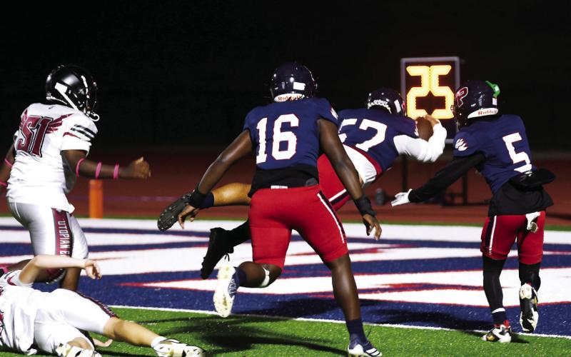 After forcing and scooping up a fumble at the 15-yard line, defensive end Steven Grandt (57) made a diving play to score in the first quarter against Utopian Academy last Friday night. IAN TOCHER/Staff