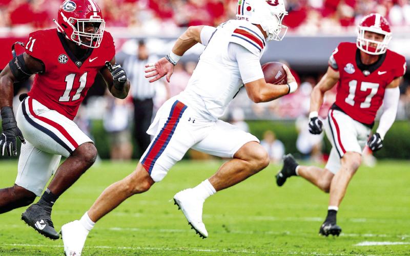 Georgia linebacker Jalon Walker (11) and defensive back Dan Jackson (17) chase down Auburn quarterback Peyton Thorne. COURTESY OF UGA ATHLETICS