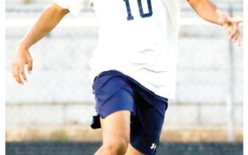 Putnam midfielder Angel Sanchez (10) dribbles past an Oglethorpe County defender in the regular season finale on April 15. The junior scored the go-ahead goal against Vidalia last Friday in overtime, helping the War Eagles advance to the second round of state playoffs. LANCE McCURLEY/Staff