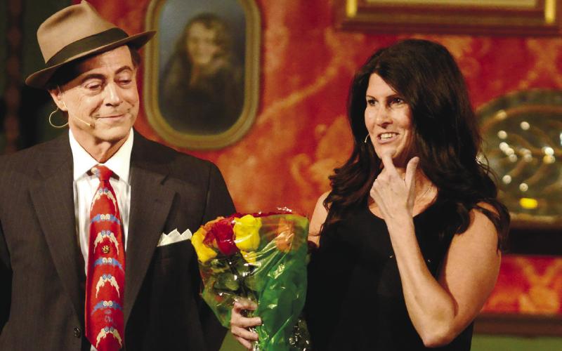 Actor Michael Homeier watches as first-time director Mo Brower receives flowers following a successful run of “Arsenic and Old Lace” at Greensboro’s Festival Hall.