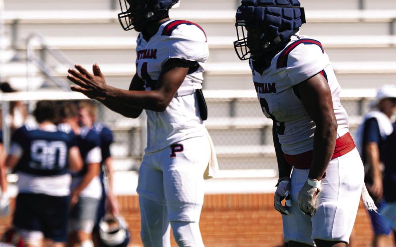 Putnam County quarterback Caleb Reeves (left) gets set to take a snap from the shotgun formation during the team’s padded camp in Eatonton on July 16. JCVISUALS/Contributed