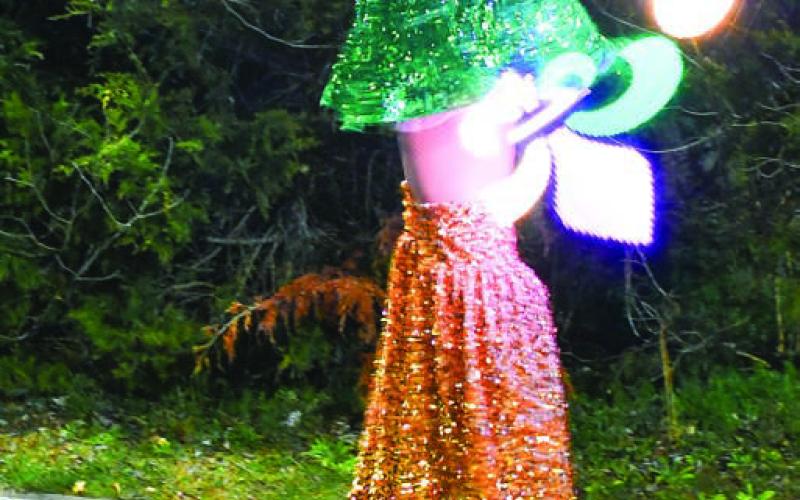 New Orleans-style street performers entertained the Artigras crowd, including this stilted lady swinging light sticks that created Fleur de Lis around her.