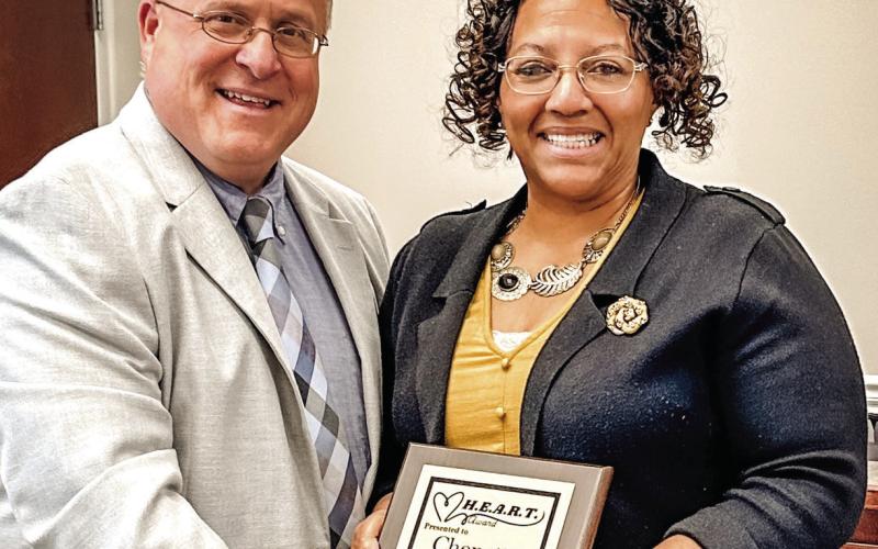 Sauls presents Chenetta Thompkins with the school system H.E.A.R.T. Award. LINDSEY RICKMAN/PCCSS