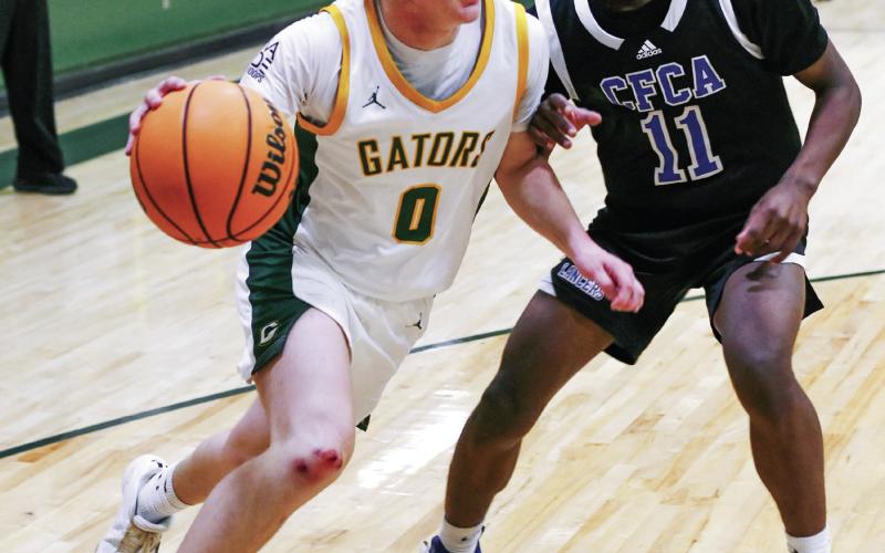 Gatewood’s Bennett Haley (0) attempts to drive the ball inside the lane past a Central Fellowship Christian defender in a 56-50 loss to the Lancers on Jan. 13. IAN TOCHER/Staff