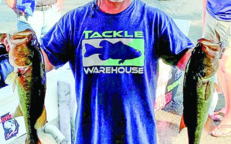 Lance Collins shows off two of the bass that helped him finish on top in the United in Pink Tournament. CONTRIBUTED