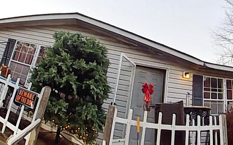The stolen partial tree, partially adorned with lights, stands on the front porch where it was easily seen by the deputy when he pulled in the driveway of the residence. CONTRIBUTED/ PCSO