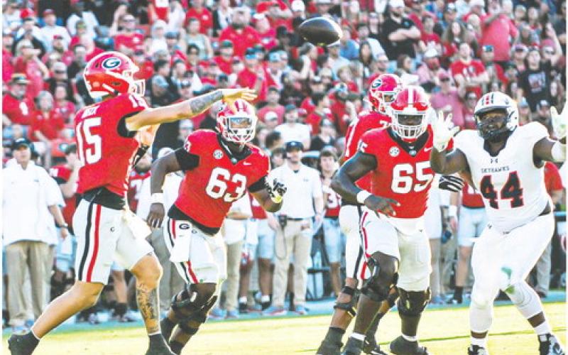 Carson Beck (15) tosses a pass to an open pass catcher in the flat. CHARLES JORDAN/Contributed