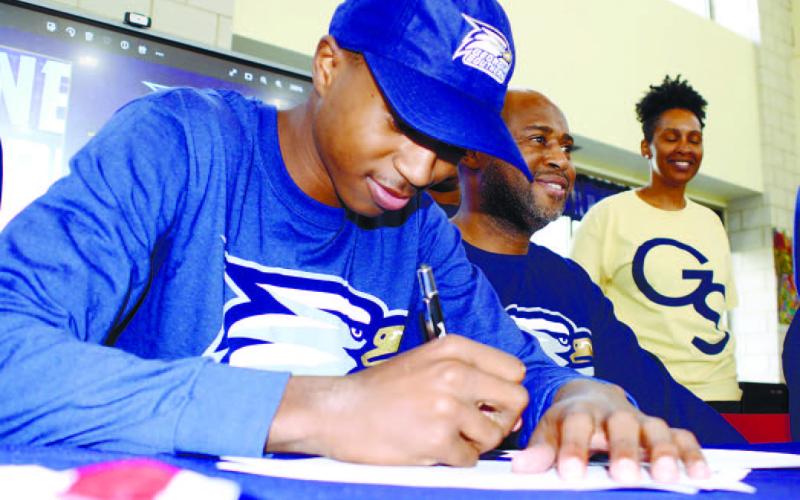 Banks signs his letter of intent to play for the Eagles while surrounded by his family. IAN TOCHER/Staff