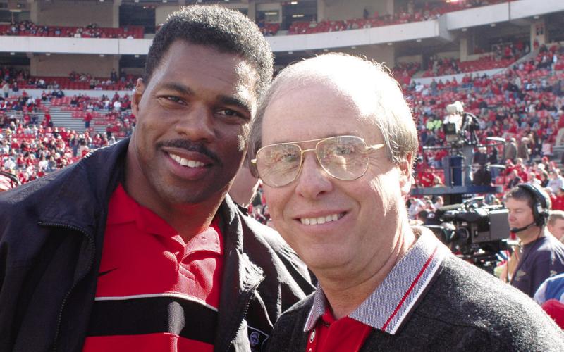 Two of the best-ever at their chosen crafts: Bulldogs’ football legend and 1982 Heisman Trophy winner Herschel Walker (left) with UGA’s legendary Sports Information and Communications Director Claude Felton on Dooley Field at Sanford Stadium in Athens. (Photo courtesy of UGA Athletics)