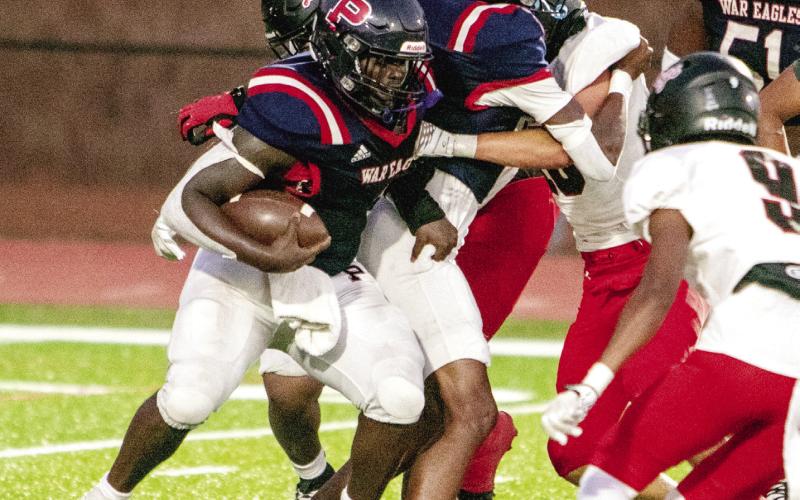 Putnam County running back Rashod Daniel (3) tries to run past Morgan County defenders in a game earlier this season. FILE PHOTO
