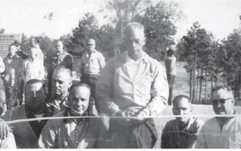 Surrounded by benefactors and inaugural members of Pine Knoll Country Club, course founder and builder Bubba Ellis prepares to cut the ribbon and officially open what is now Uncle Remus Golf Course. Back row, l-r: Johnny Harrell, Lex Rainey, Dee Hewitt and Tom Saxton; front row, l-r: Neil Hewitt, Henry Watterson, J.T. Gregory, Archie Swymer, Ellis, Melvin Harrell and Dick Stribling. Then-14-year-old Johnny Harrell provided the photo early this year, URGC Superintendent Michael Benton said. CONTRIBUTED