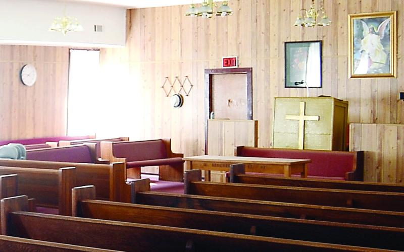 A 2023 photo depicts the interior of Rooty Creek Baptist Church, featuring wood paneling and a modest pulpit. IAN TOCHER/Staff