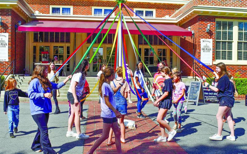 Attendees participate in the Maypole Dance under the guidance of Helen Garcia-Carreras, the choreographer at The Arts Barn. According to her, the maypole dance is a German tradition celebrating the revival of nature. Her mother, Lora Garcia-Carreras, owner of The Arts Barn, studied dances of various countries and was inspired by this German tradition.