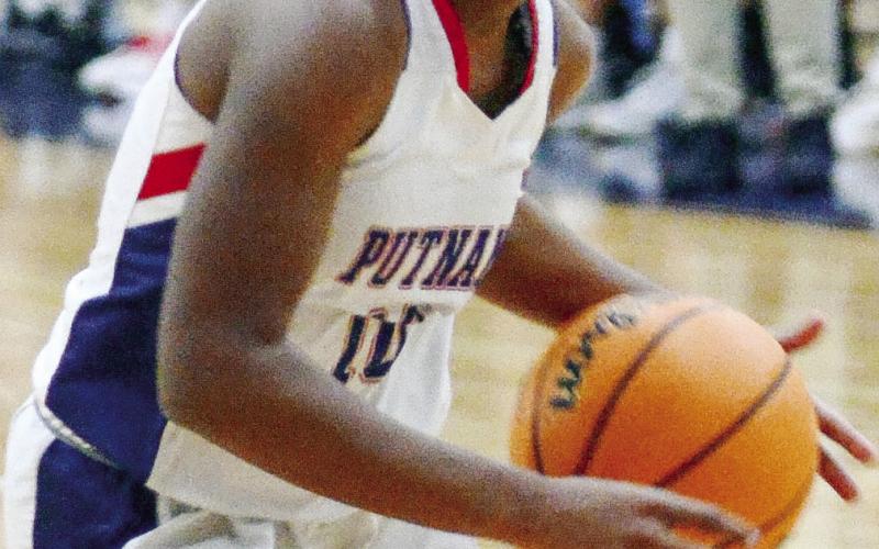 Putnam County junior Journey Waller (10) dribbles the ball through traffic in an effort to try and score during a rivalry game against Morgan County on Dec. 14. IAN TOCHER/Staff