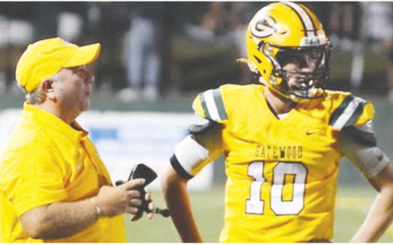 Gatewood head coach Jeff Ratliff confers with quarterback Ames Johnson during the second quarter of last Friday’s game against Briarwood Academy. IAN TOCHER/STAFF