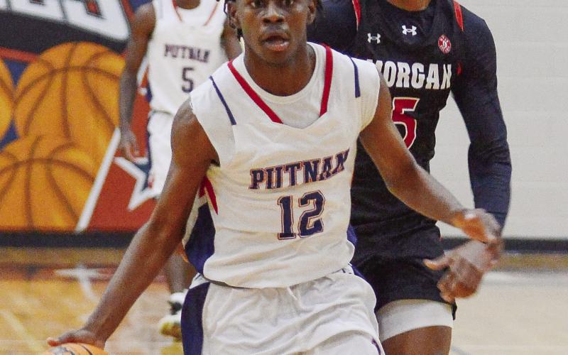 Putnam County’s Shamar McClendon (12) dribbles the ball down the court on a fast break. IAN TOCHER/Staff