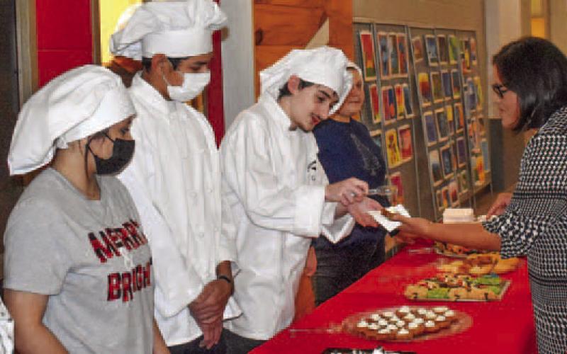 David McDade serves dessert to City Clerk Maria Jimenez, as fellow culinary students (l-r) Mariafernanda Rangel, Gisselle Martinez, Angel Ledesma and Gabrianna Gearhart wait for more visitors.