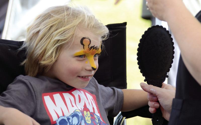 A young visitor admires the artwork applied by a face painter at The Big Event. IAN TOCHER/Staff