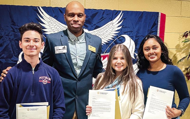 Georgia Tech’s Antwuan Holloway (center) visited Putnam County High School Dec. 5 to notify PCHS seniors (l-r) Carlos Jimenez, Carolyn Thomas, and Vidhi Raiyani, that they had each been accepted into the prestigious, downtown Atlantabased university through its highly competitive Early Action program. CONTRIBUTED