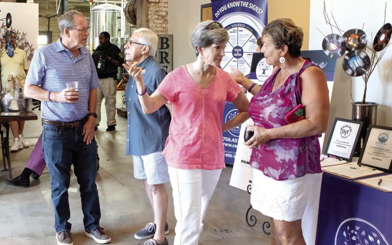 Inside the brewery attendees meet up, sign in, and check out the auction items. (LEIGH LOFGREN/Staff)