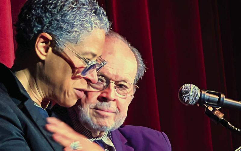 With Larry Moore by her side, Rebecca Walker is emotionally taken by seeing her father’s handwritten inscription inside the front cover of her mother Alice Walker’s first book, a collection of poems published in 1968. IAN TOCHER/Staff
