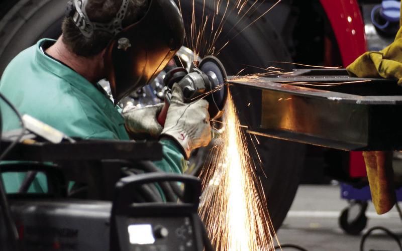 Sparks fly as a Fouts Bros. worker uses a grinder on the frame of a firetruck. IAN TOCHER/Staff
