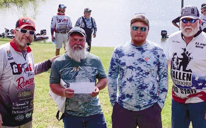 Host Mike Tarrer and Oskar Schlomer of The Fallen Outdoor group congratulate big fish winners Jason Long and Kody Nixon. CONTRIBUTED