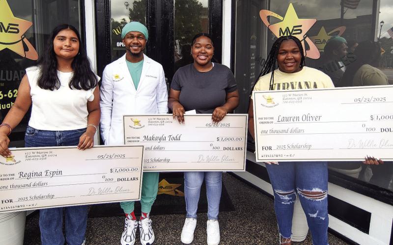 Dr. Willie Oliver congratulated (l-r) Putnam County High School graduates Regina Aspen, Makayla Todd, and Lauren Oliver as recipients of his $1,000 Most Valuable Smiles scholarships, as each will begin attending various universities this year. IAN TOCHER/Staff