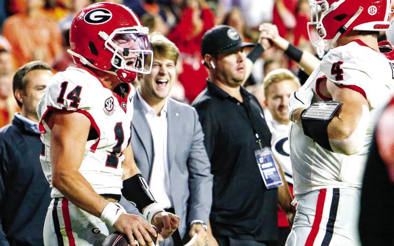 Georgia quarterback Gunner Stockton (left) celebrates with tight end Oscar Delp (right) after icing the game with a 10-yard touchdown run late in the fourth quarter against Auburn. LANCE McCURLEY/Staff