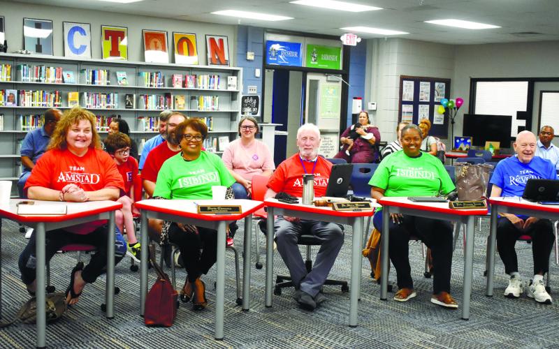 Members of the board of education pose in their new housing shirts, given to them during the sorting ceremony.