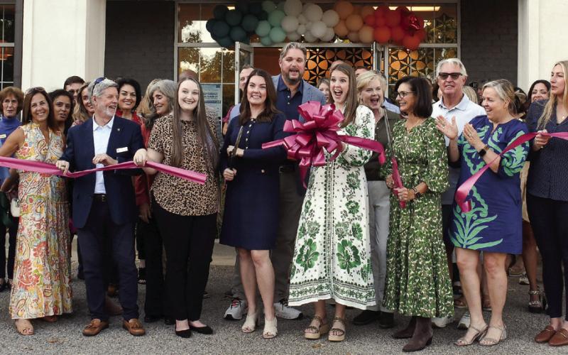 Rachel Beeker (center, blue dress) completed a second ribbon-cutting last Thursday to officially recognize a new home for her Silver Lining Promos company. IAN TOCHER/Staff